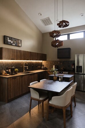 A modern kitchen with a central island, wooden cabinetry, and a built-in oven. - Twelve34 House+ Penthouse in the Trees + Wall of Glass + Hot Tub (Laurelville)