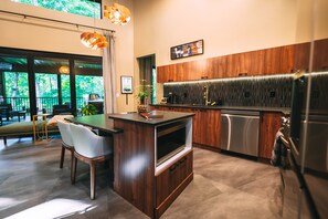 A modern kitchen with a wooden island, stainless steel appliances, and a view of the outdoors. - Twelve34 House, Penthouse in the Trees, Luxury Hocking Hills, Trails (Laurelville)