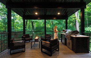 An outdoor deck with a grill, seating, and a fire pit. - Twelve34 House, Penthouse in the Trees, Luxury Hocking Hills, Trails (Laurelville)