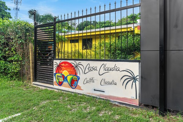Una entrada cerrada con un mural de gafas de sol y palmeras, y el texto 