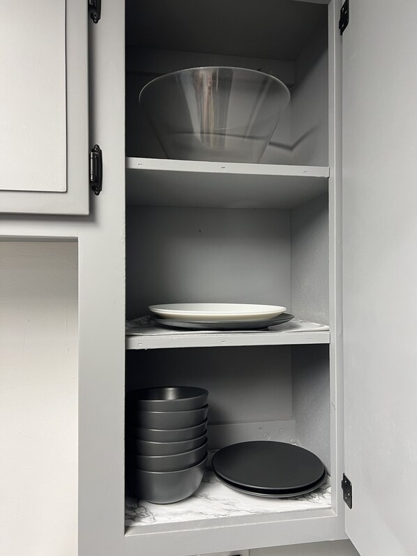 A kitchen cabinet with shelves holding various kitchenware. - Ideal for Families • Clean, Modern & Spacious 2BR (Fair Oaks)