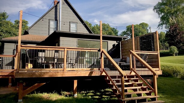 A modern house with a large deck, a staircase, and a chimney. - Parkman Pad: hot tub, wood stove by Montague breweries (Montague)