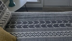 Ett rum med en säng, en lampa och utsikt över en strand och en pool genom en glasdörr.
