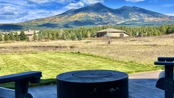 A circular outdoor seating area with a view of a mountain and a building in the background.