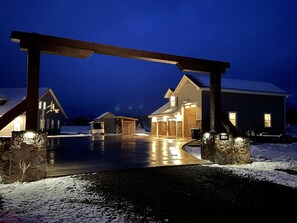 Een groot huis met een overdekte oprit en een stenen muur.