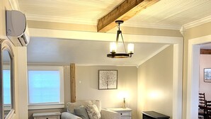 Una sala de estar con un sofá modular, una mesa de centro de madera, una chimenea y una araña.