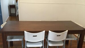 Une table à manger avec quatre chaises blanches et un plancher en bois.