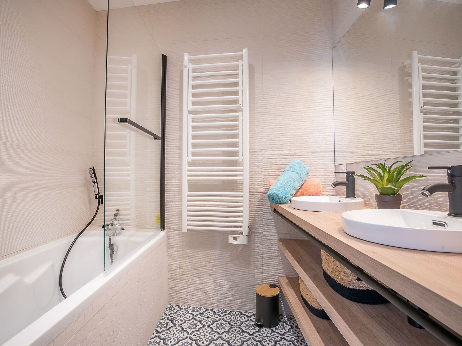 A modern bathroom with a bathtub, a sink, and a mirror.