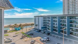 A multi-story hotel with a parking lot, a pool, and a view of the beach. - Retreat by the Sea (Myrtle Beach)