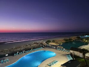 A pool area with lounge chairs, a beach, and a sunset view. - Retreat by the Sea (Myrtle Beach)