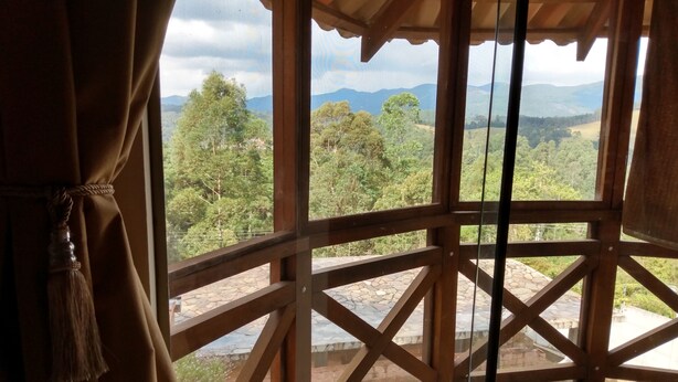 A wooden balcony with a view of a mountainous landscape.