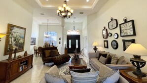 A spacious living room with a chandelier, sofas, and a dining area. - * Waterfront home to relax, reconnect, and create unforgettable memories together! * (Rotonda West)