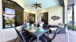An outdoor patio with a dining table set for four, surrounded by wicker chairs. - * Waterfront home to relax, reconnect, and create unforgettable memories together! * (Rotonda West)