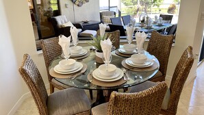 A dining area with a glass table set for six, surrounded by wicker chairs with grey cushions. - * Waterfront home to relax, reconnect, and create unforgettable memories together! * (Rotonda West)