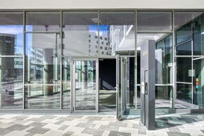 Enter through the revolving door into a sleek, contemporary space with a view of the surrounding urban environment.