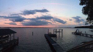 A calm lake at dusk with a dock extending into the water.