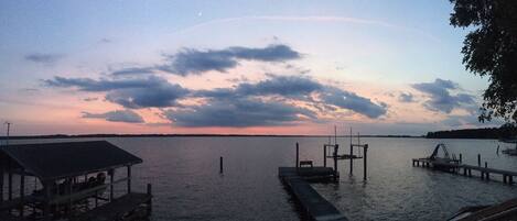 A calm lake at dusk with a dock extending into the water.