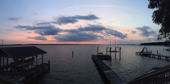 A calm lake at dusk with a dock extending into the water.