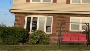 A two-story house with a brick foundation and beige siding.