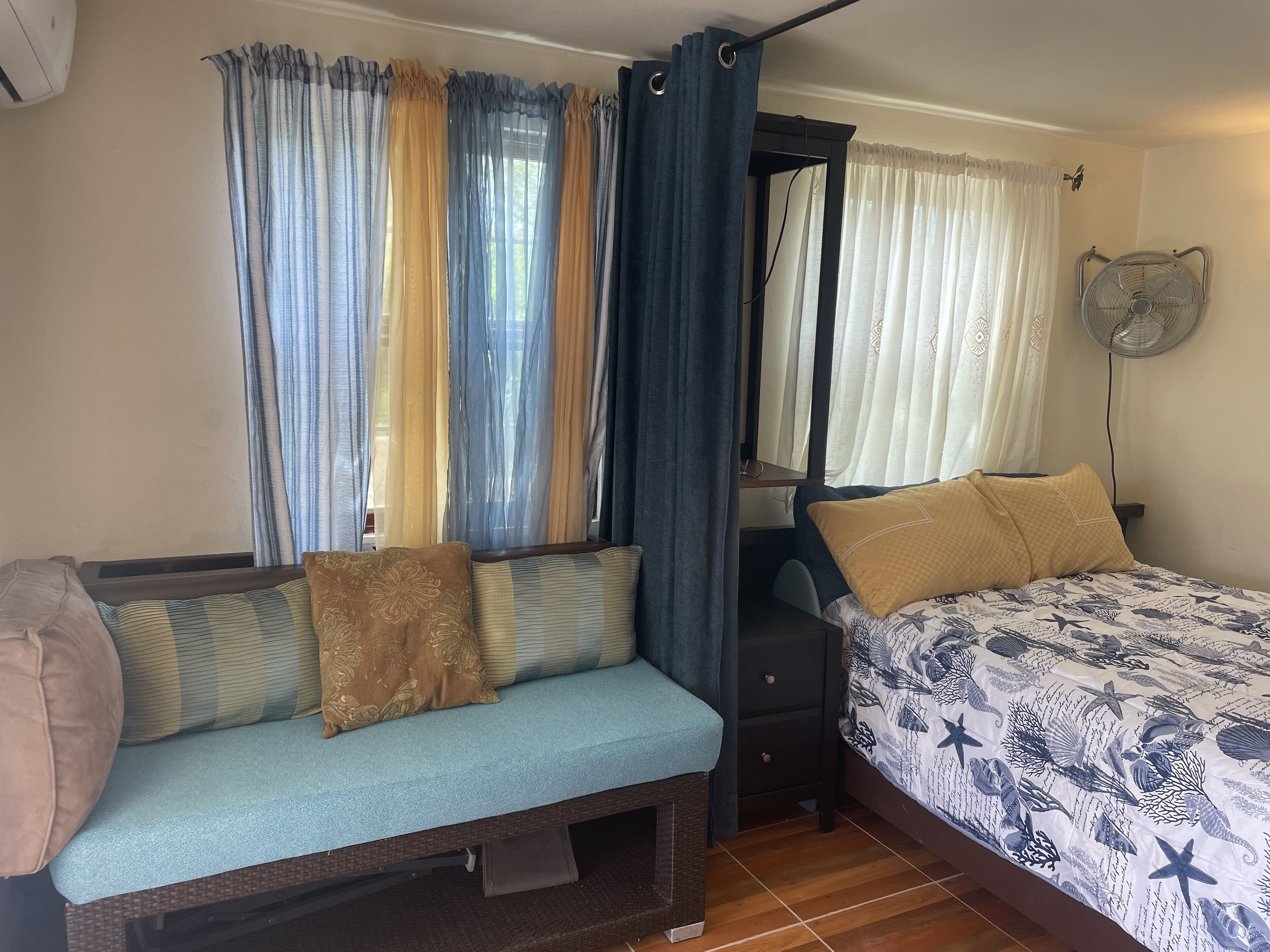 A room with a bed, a bench, and a bedside table.