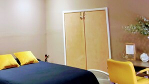 Un dormitorio con cama, escritorio y armario.