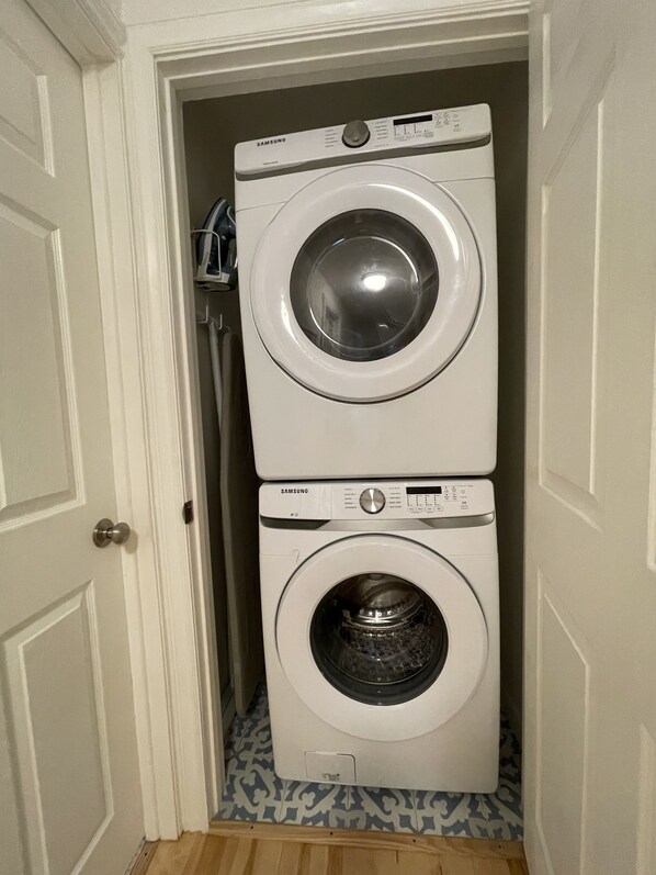 A white wall-mounted washer and dryer unit with a control panel and a door.