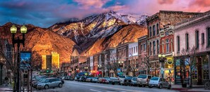 A street lined with historic buildings, a mountain backdrop, and parked cars. - Mid-Century Modern Gem next to Trails, Ski Resorts and Downtown Ogden (Ogden)