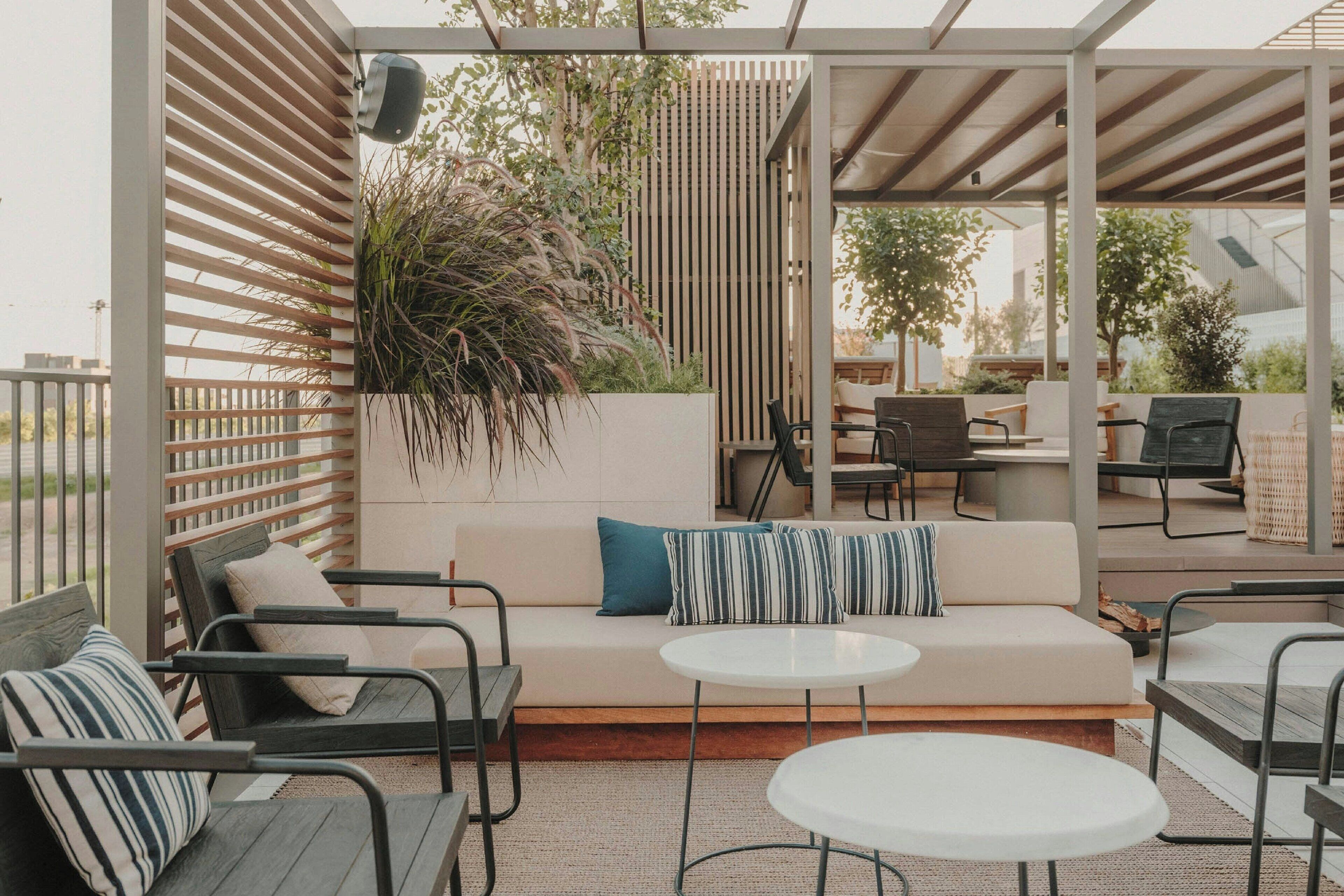 An outdoor patio with a sofa, chairs, and a round table.