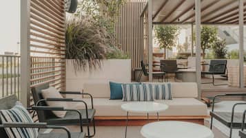 An outdoor patio with a sofa, chairs, and a round table.