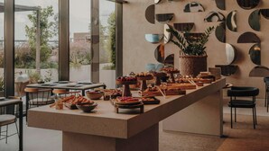 Montaje de bufé con diferentes opciones de comida y una pared decorativa con espejos circulares.