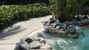 A landscaped garden with a curved pathway, a rock feature, and a pool. - Quiet Noosaville Garden Retreat, Pool, Walk to River & Dining (Noosaville)