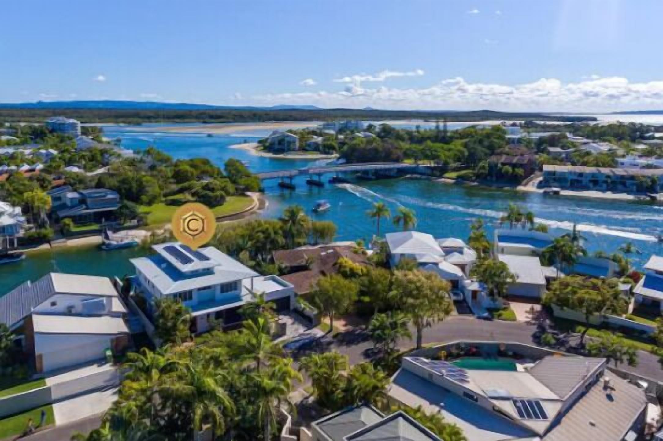 A coastal resort with modern villas, a marina, and a beach.