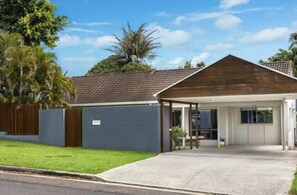 Guests can enjoy a peaceful stay in this single-story building with a covered entrance and beautifully maintained lawn.
