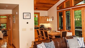 Ein geräumiges Wohnzimmer mit Holzboden, einem braunen Ledersofa und einem Essbereich mit Holzmöbeln.