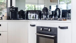 Una cocina con horno empotrado, cafetera y tostadora.