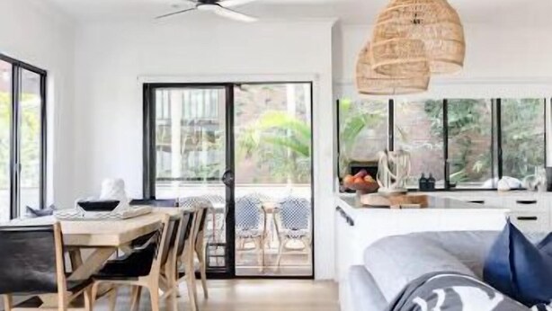 Una cocina moderna con comedor, ventanas amplias y un ventilador de techo.