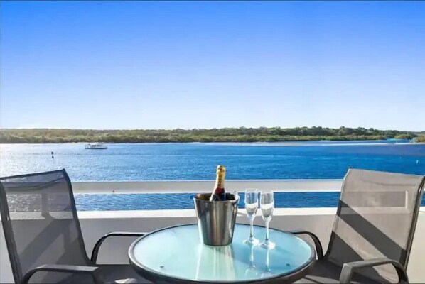 Enjoy a tranquil moment on the balcony with a glass of champagne and a serene lake view.