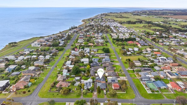 An aerial view of a residential area with houses, roads, and a coastline. - Time to Relax - Stunning getaway in a prime location. (PORTARLINGTON)