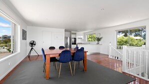 A modern kitchen with white cabinets, a stainless steel refrigerator, and a built-in oven.