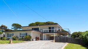 A modern two-story house with a covered patio and a driveway.