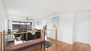 Un vaste espace de vie doté d’un haut plafond, d’un escalier et donnant sur un balcon extérieur.