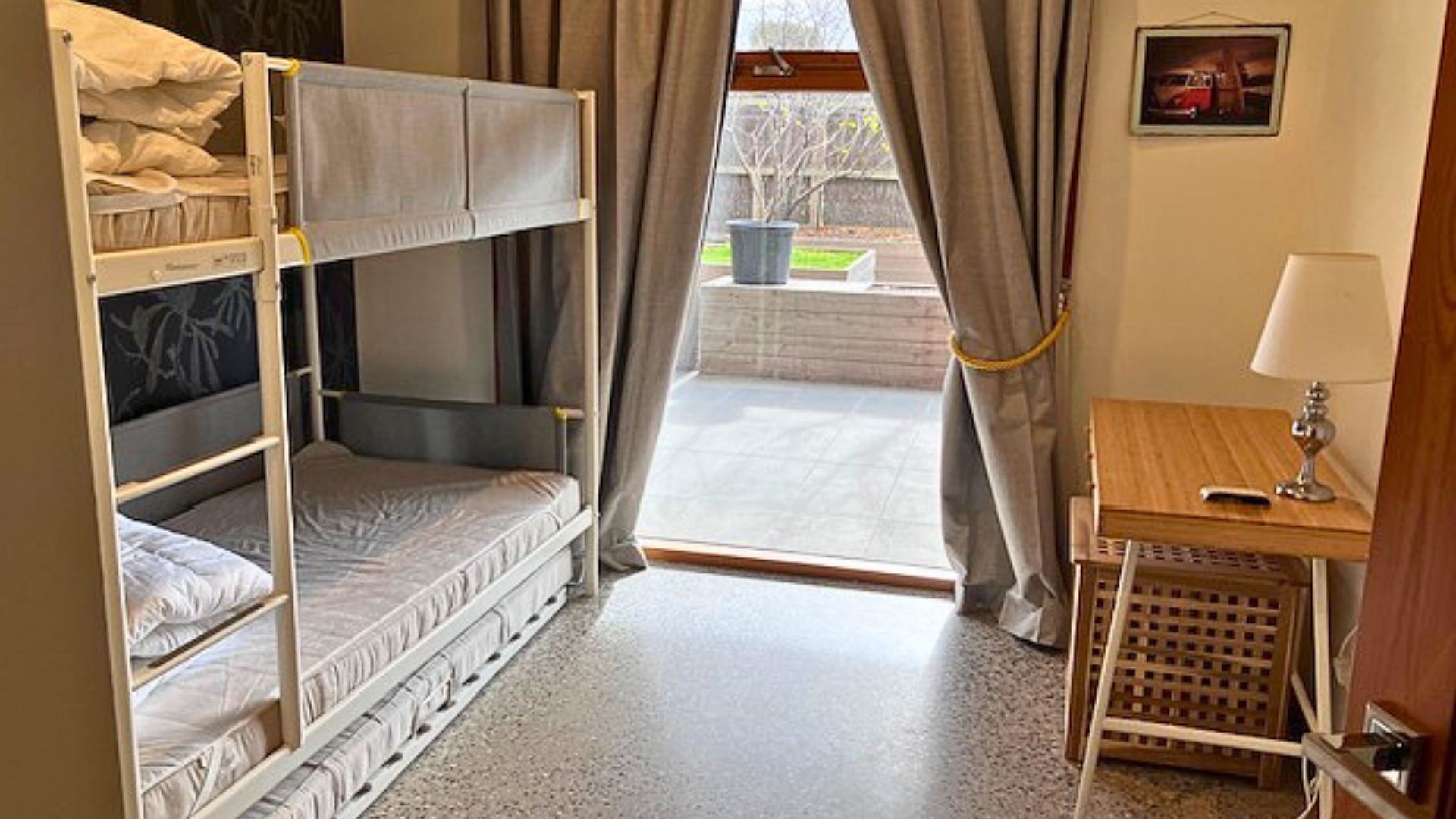 Une chambre avec un lit superposé, un bureau et une lampe.