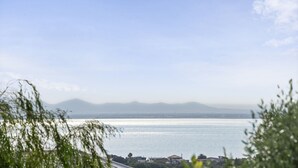 Une vue sur la côte, avec un ciel dégagé, une mer calme et des montagnes à l’horizon.