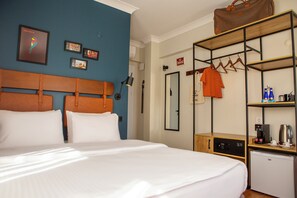 A hotel room with a bed, a wardrobe, a desk, a coffee machine, and a small refrigerator. - The Abies (Çanakkale)