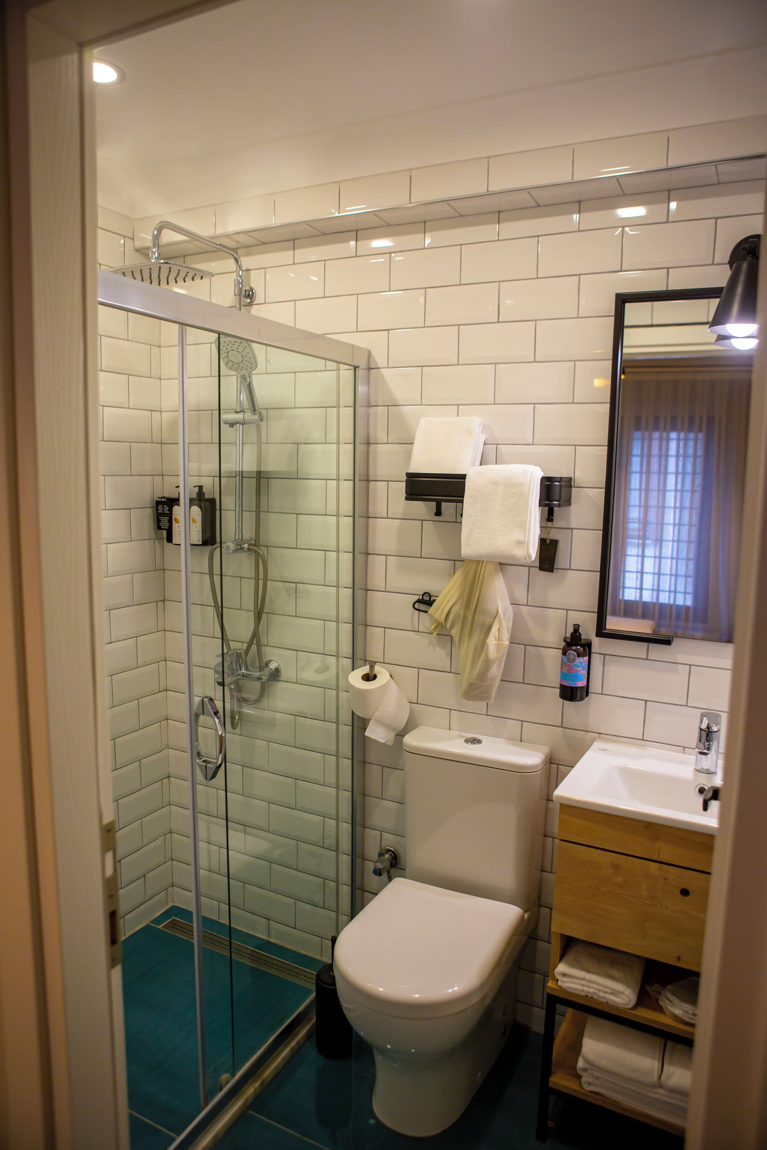 Un baño con ducha envuelta en vidrio, inodoro y lavamanos.