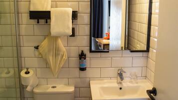 Un baño pequeño con inodoro, lavamanos y espejo.