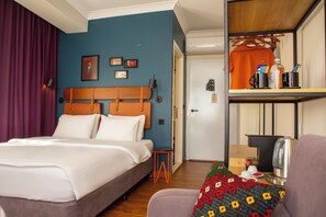 A hotel room with a bed, a small table with a kettle, a chair, and a shelf with toiletries. - The Abies (Çanakkale)