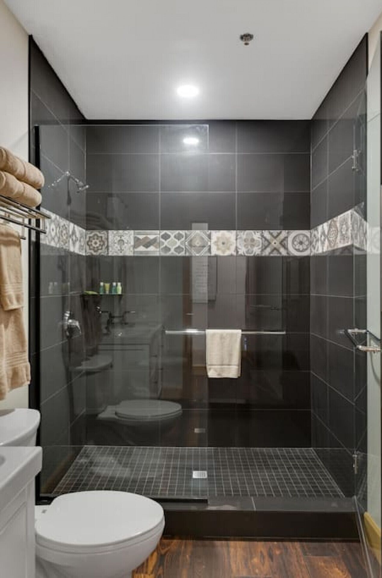 Ein modernes Badezimmer mit einer Duschkabine aus Glas, einer Toilette und einem Waschbecken.