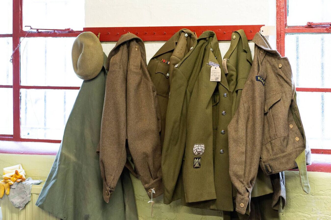 En samling jackor i militär stil hänger på en klädställning.