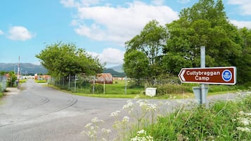 A rural road with a sign for Cultybraggan Camp.